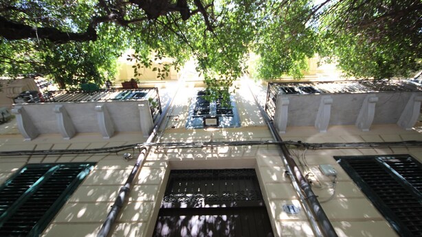 A courtyard with a central water feature, surrounded by columns and shaded by trees. - Convenient and cozy apartment in the heart of the city nearby historic center (Palermo)