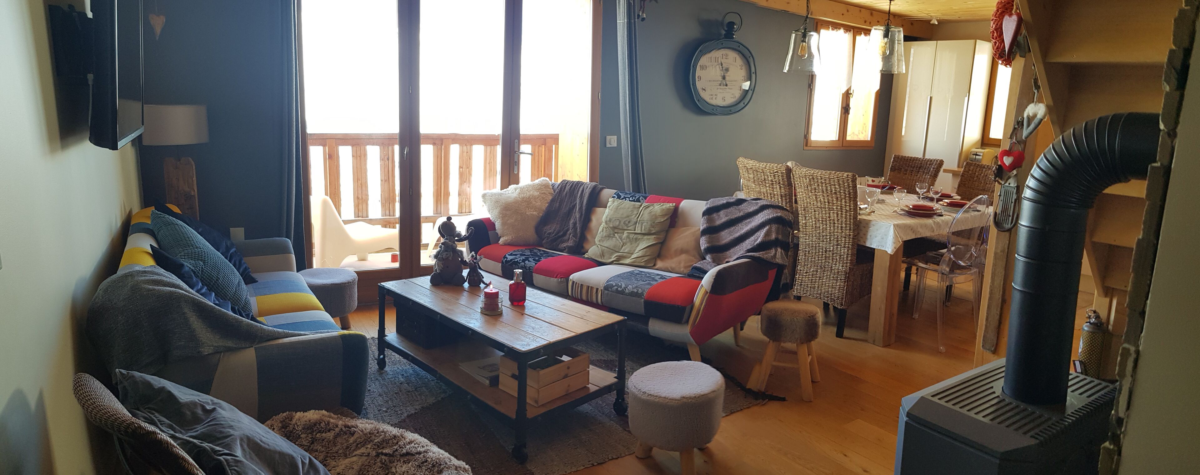 A cozy living room with a sofa, coffee table, and dining area.