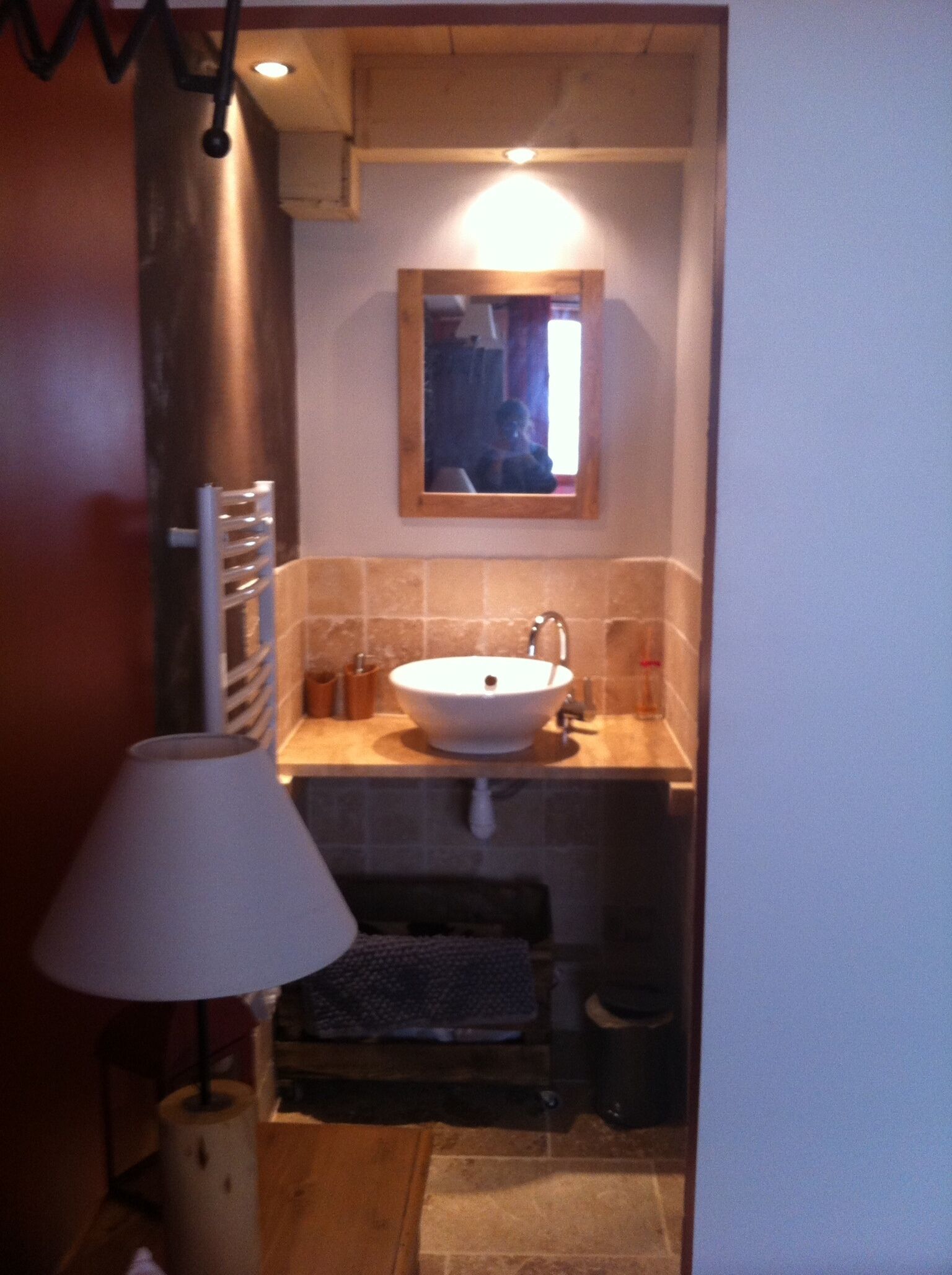 A small bathroom with a sink, mirror, and towel rack.