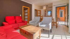 A living room with a red sofa, a wooden coffee table, and two white armchairs. - Rural house Montseny, Cal Metge (GUALBA)