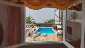 An open door to a room with a view of a swimming pool, stone flooring, and outdoor furniture. - Little house with pool on La Palma (Los Llanos de Aridane)
