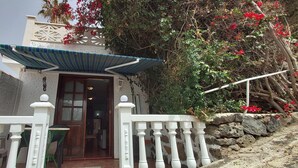 A building with a white exterior, a wooden door, and a white railing. - Little house with pool on La Palma (Los Llanos de Aridane)
