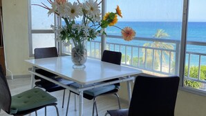 A dining area with a table, chairs, and a vase of flowers. - Beautiful Seafront 3Bed, 2Bath, wifi, first line in Altea (Altea)
