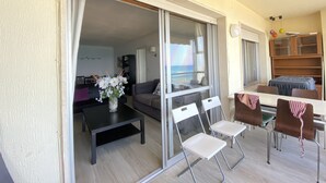 A balcony with a dining table, chairs, and a vase of flowers. - Beautiful Seafront 3Bed, 2Bath, wifi, first line in Altea (Altea)