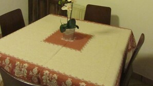Una mesa de comedor con mantel floreado, rodeada de sillas.