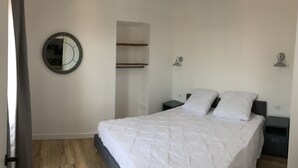 A bedroom with a bed, two bedside tables, a nightstand, a mirror, and built-in shelving. - 2 rooms MASSENA pedestrian zone WIFI - CLIM (Nice)