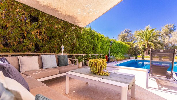 An outdoor seating area with a pool, a sofa with cushions, and a table. - Villa Sa Cabaneta with pool, tennis court, and views to the Palma Bay (Marratxi)