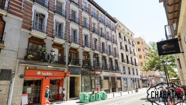 A multi-story building with a cafe and a bakery on the ground floor. - Atocha - 2-Bedroom Apartment in Downtown Madrid (Madrid)