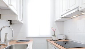 Una cocina moderna con un fregadero, un tostador, una estufa y una ventana.