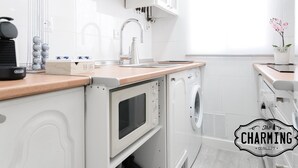 A compact kitchen with a sink, a coffee machine, and a microwave. - Atocha - 2-Bedroom Apartment in Downtown Madrid (Madrid)