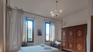 A bedroom with a bed, bedside table, chair, and a wooden cabinet.