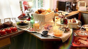 Um buffet de café da manhã com diversas opções de alimentos, incluindo frutas, pães e bebidas.
