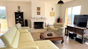 A living room with a fireplace, a sofa, a coffee table, and a TV. - House / Villa - Saint Chels (Saint-Chels)