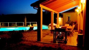 A covered outdoor area with a pool, seating, and a patio table. - House / Villa - Saint Chels (Saint-Chels)