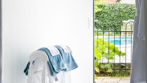 Una habitación con una puerta blanca que da a un balcón con piscina.
