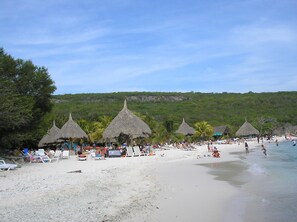 Na praia, espreguiçadeiras, toalhas de praia 