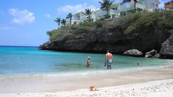 Na praia, espreguiçadeiras, toalhas de praia