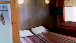 A room with two beds, a wooden headboard, a television mounted on the wall, and a window with curtains. - Nice renovated apartment ** Terrace, skiing, parking, shops at 30m (La Plagne Tarentaise)