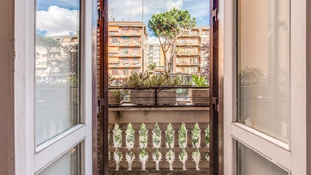A balcony with potted plants, a view of residential buildings, and a clear sky. - Finally In Rome Vatican Apartment - 3 Double Rooms 100MQ (Roma)