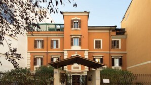 A multi-story building with a central entrance, a covered area, and a gated driveway. - Finally In Rome Vatican Apartment - 3 Double Rooms 100MQ (Roma)