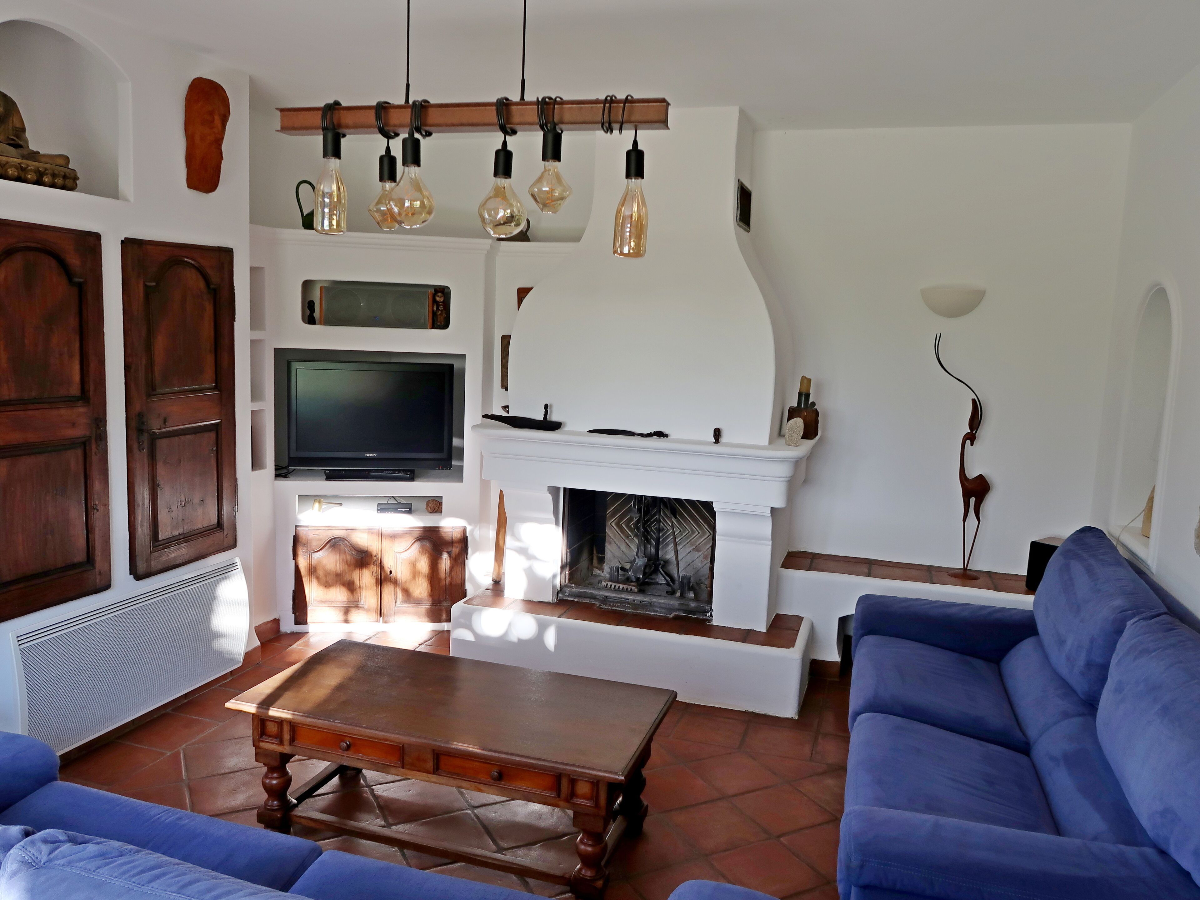 A living room with a fireplace, a television, and a sofa.