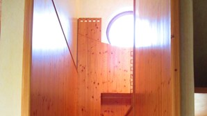 Eine Holztreppe mit einem runden Oberlicht oben.