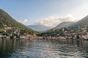 A lakeside town with buildings along the shore, surrounded by hills.