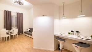 Eine moderne Küche mit Essbereich, einer Couch und zwei Barhocker.