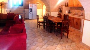 A cozy, open-plan living and dining area with a kitchen, featuring a dining table, chairs, and a red sofa. - EUROLUCANIA GUESTHOUSE2 ROOM3 (Bari)