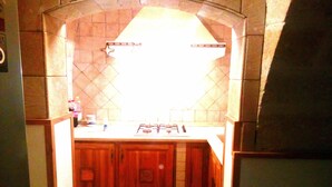 A kitchen with a tiled backsplash, wooden cabinets, and a gas stove. - EUROLUCANIA GUESTHOUSE2 ROOM3 (Bari)