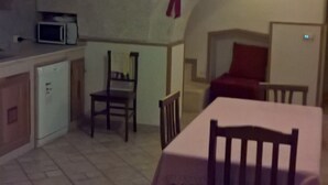 A compact kitchen with a microwave, a refrigerator, and a dining area with a table and chairs. - EUROLUCANIA GUESTHOUSE2 ROOM3 (Bari)