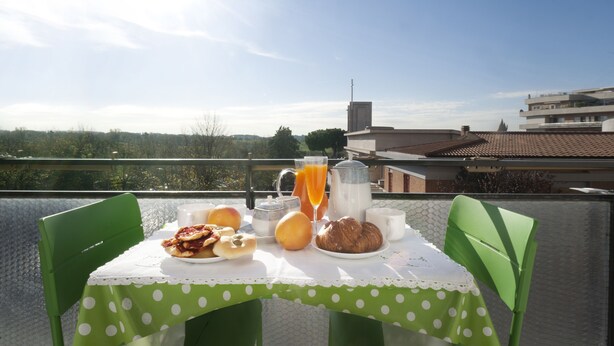 A dining table with breakfast items and a view of the cityscape. - Central, next to the Metro, overlooking the famous Appia Antica Park (Roma)