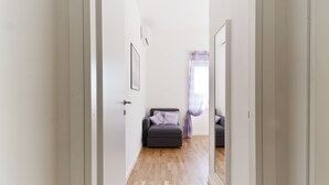 A narrow hallway with a grey sofa and a purple curtain. - Central, next to the Metro, overlooking the famous Appia Antica Park (Roma)
