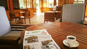 Une table en bois, un journal et une tasse de café.