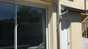 A building with a large sliding glass door, a small door, and a window.