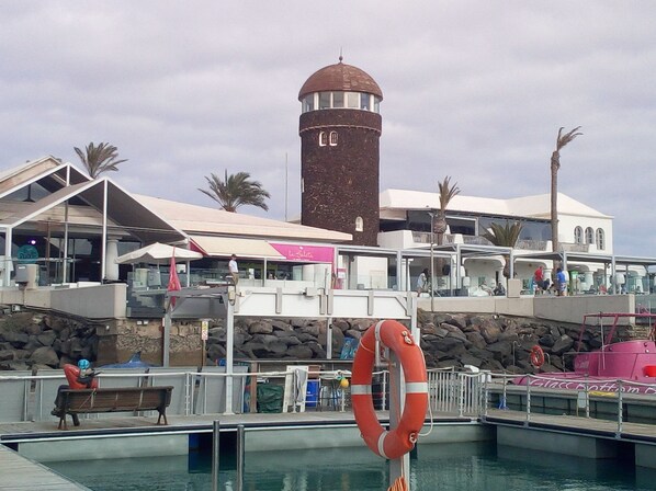 A coastal building with a lighthouse, a pool, and a lifebuoy.