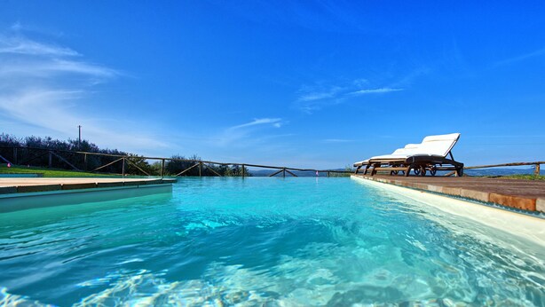 A clear blue pool with lounge chairs and a wooden deck. - Lovely apartment for 6 people with A/C, pool, WIFI, TV and panoramic view, close to San Gimignano (Poggibonsi)