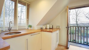 A kitchen with a wooden countertop, a sink, and a window with blinds. - Comfortable Cosy Private Barn conversion, Own courtyard, parking, nr to station (Hertford)