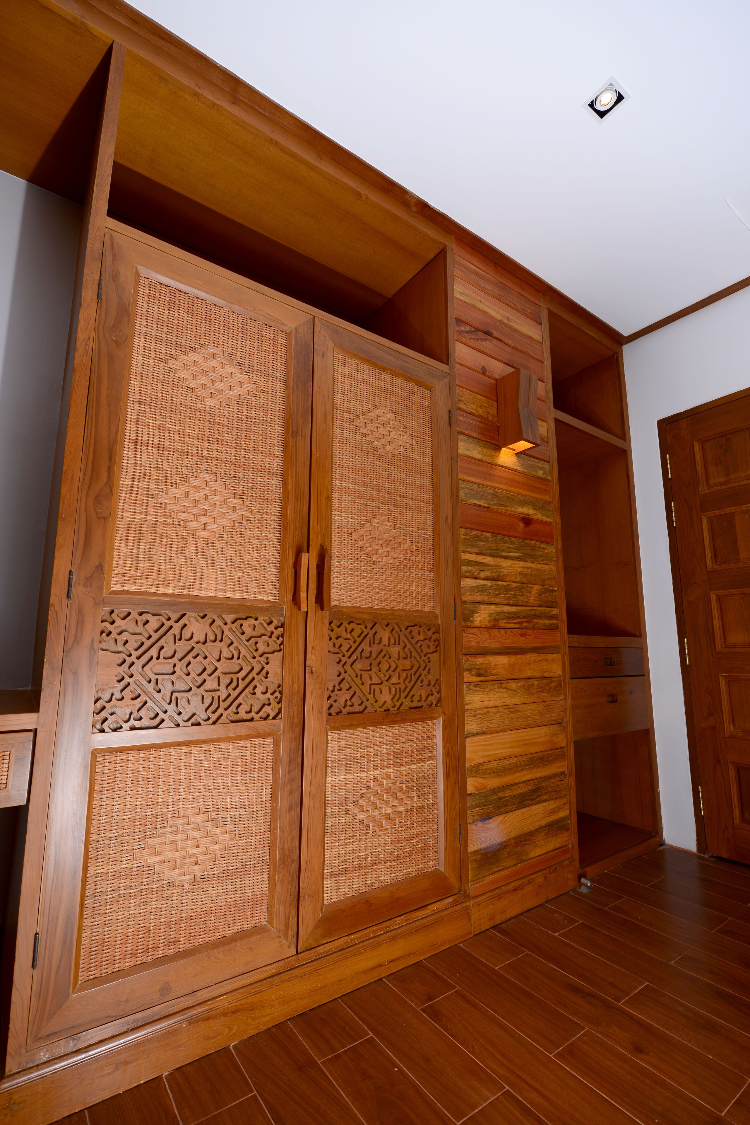 Un armario de madera con elaborados grabados y luz integrada.