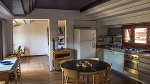 A modern kitchen with a dining area, wooden furniture, and a built-in dishwasher. - Attic of great charm with terraces and panoramic views (Roma)