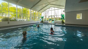An indoor swimming pool with clear glass walls, a tiled floor, and a high ceiling. - EuroParcs Spaarnwoude (Halfweg)