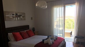 Une chambre d’hôtel avec un grand lit, une table de chevet, une lampe, une fenêtre avec des rideaux et une vue sur l’extérieur.