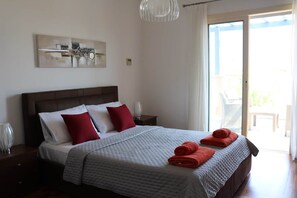 A hotel room with a large bed, a view of the outdoors, and a painting on the wall.