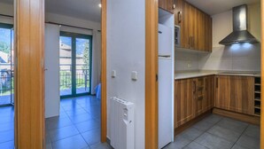 A kitchen with wooden cabinets, a built-in oven, and a stainless steel range hood.