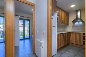 A kitchen with wooden cabinets, a built-in oven, and a stainless steel range hood.