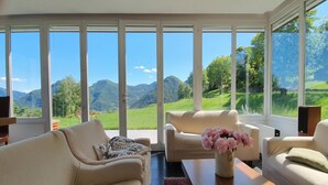 A modern living room with a large window offering a mountain view. - Villa Intelvi, Cerano d'Intelvi, Italy (Cerano d'Intelvi)