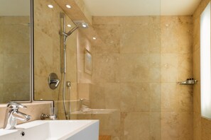 Een moderne badkamer met een grote spiegel, een wastafel en een douche.