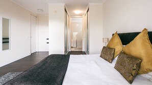 Ein Schlafzimmer mit einem großen Bett, einem dunklen Kopfteil und zwei Zierkissen.