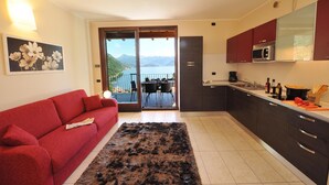 Eine moderne Küche mit Seeblick, ein rotes Sofa und ein Essbereich.