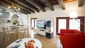 A modern living room with a dining area, a television, and a red sofa. - Singular Stays A. San Vicente IV (Valencia)